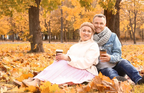 Щаслива зріла пара п'є каву в осінньому парку — стокове фото