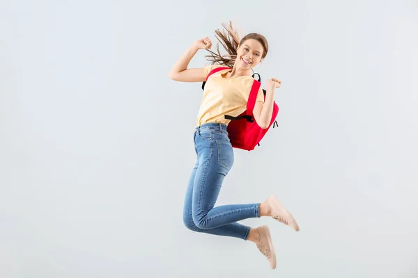 Studentin springt vor hellem Hintergrund — Stockfoto