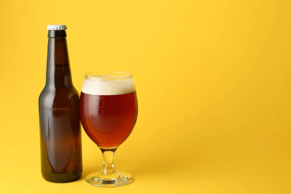 Glass and bottle of fresh beer on color background — Stock Photo, Image