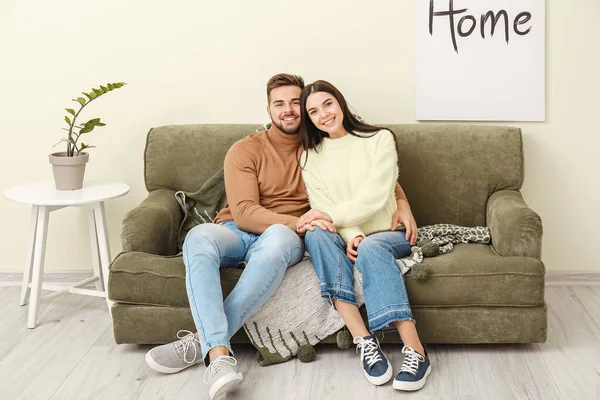Jovem casal sentado no sofá em casa — Fotografia de Stock