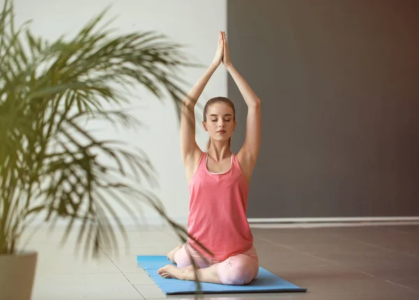 Bella giovane donna che pratica yoga a casa — Foto Stock