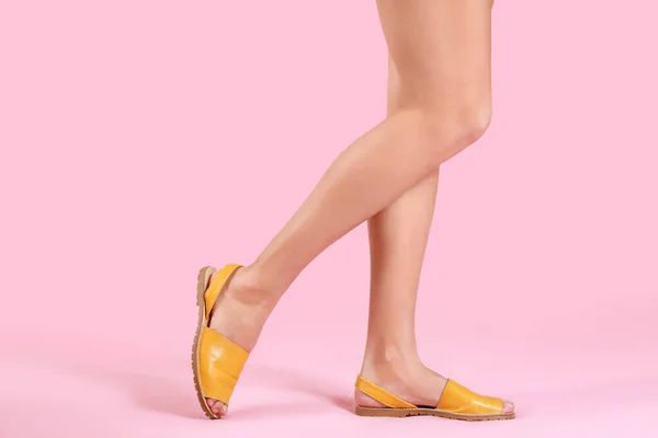 Ноги молодої жінки в стильному взутті на кольоровому фоні — стокове фото