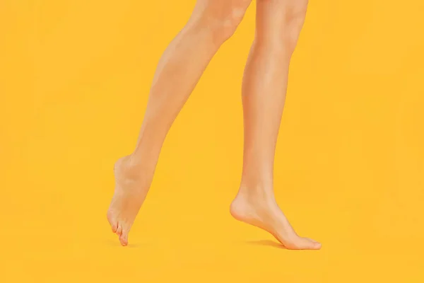Las piernas de la hermosa mujer joven en el fondo de color —  Fotos de Stock