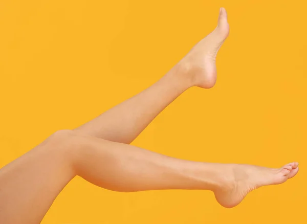 Ноги красивої молодої жінки на кольоровому фоні — стокове фото