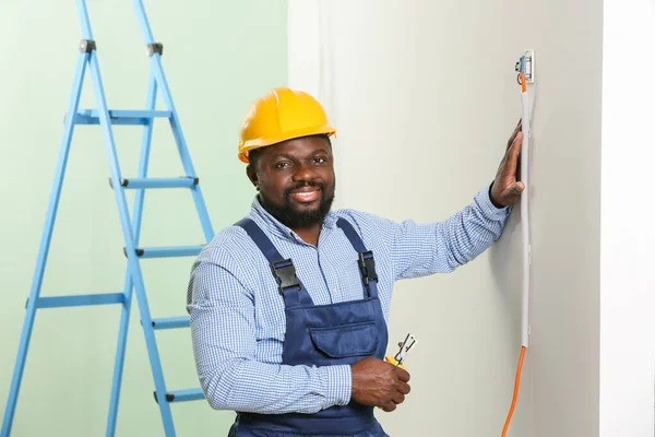 African-American electrician installing switch in room — Stock Photo, Image