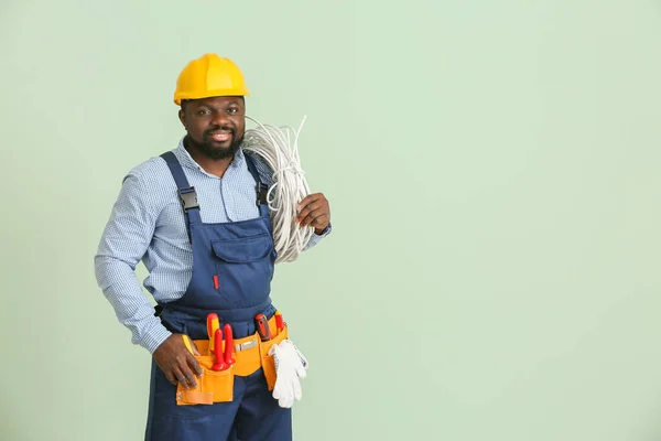African-American electrician on color background — Stock Photo, Image