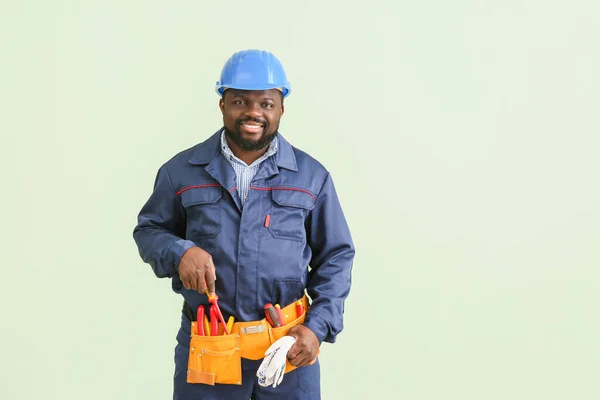 African-American electrician on color background — Stock Photo, Image