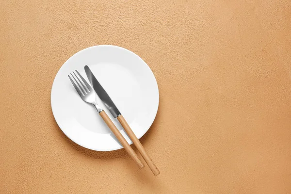 Empty plate and cutlery on color background — Stock Photo, Image