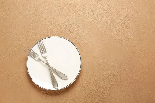 Empty plate and cutlery on color background — Stock Photo, Image