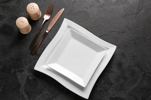 Empty plates and cutlery on dark background — Stock Photo, Image