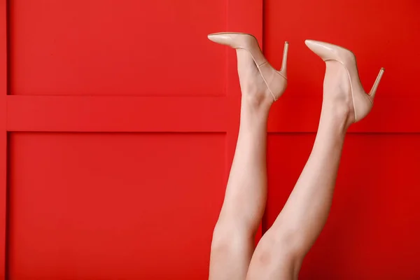 Nogi młodej kobiety w stylowych wysokich obcasach na tle koloru — Zdjęcie stockowe