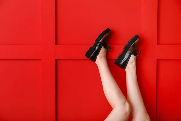 Legs of young woman in stylish shoes against color background — Stock Photo, Image