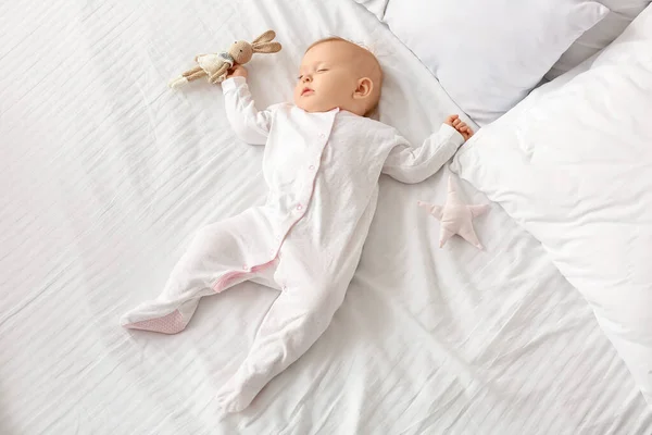 Χαριτωμένο μωρό με παιχνίδι κοιμάται στο κρεβάτι — Φωτογραφία Αρχείου