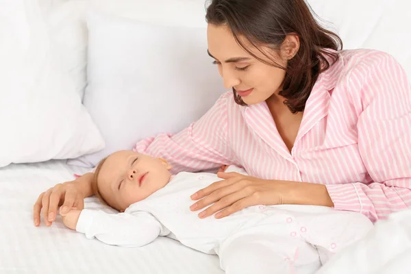 Young woman and her sleeping baby in bed — Stock Photo, Image