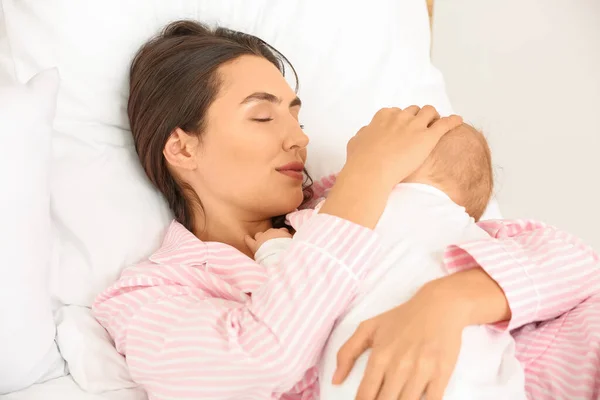 Mujer joven y su bebé durmiendo en la cama —  Fotos de Stock