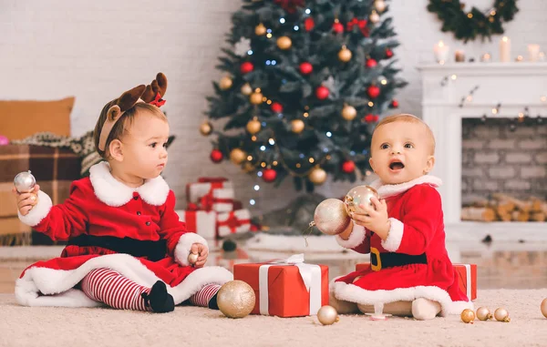 Χαριτωμένα μωρά σε κοστούμι Άγιος Βασίλης και με δώρα Χριστουγέννων στο σπίτι — Φωτογραφία Αρχείου