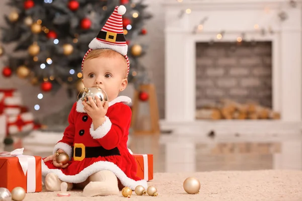 Cute little baby in Santa Claus costume and with Christmas gifts at home — Stock Photo, Image