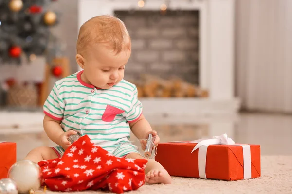 Niedliches kleines Baby mit Weihnachtsgeschenken zu Hause — Stockfoto