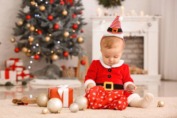 Carino bambino in costume da Babbo Natale e con regali in camera decorati per Natale — Foto Stock