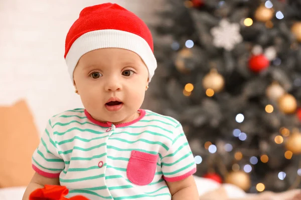 Bebê bonito com chapéu de Papai Noel na véspera de Natal em casa — Fotografia de Stock