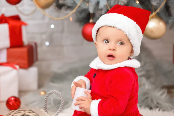 Bebê bonito em traje de Papai Noel na véspera de Natal em casa — Fotografia de Stock