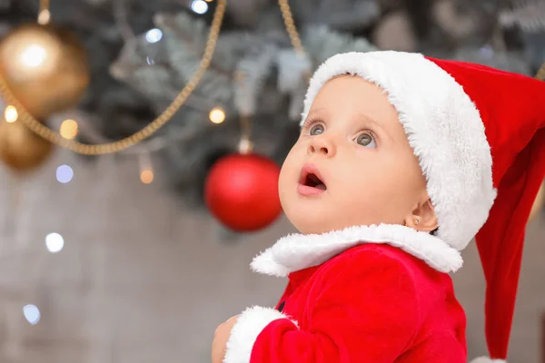 Bebê bonito em traje de Papai Noel na véspera de Natal em casa — Fotografia de Stock