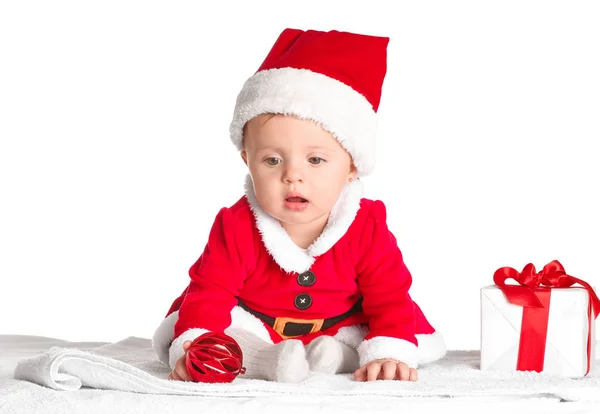 Cute little baby in Santa Claus costume and with Christmas gift on white background — Stock Photo, Image