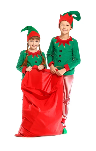 Little children in costume of elf and with Santa Claus bag on white background — Stock Photo, Image