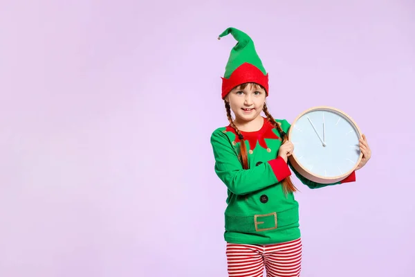 Bambina in costume da elfo e con orologio sullo sfondo a colori — Foto Stock