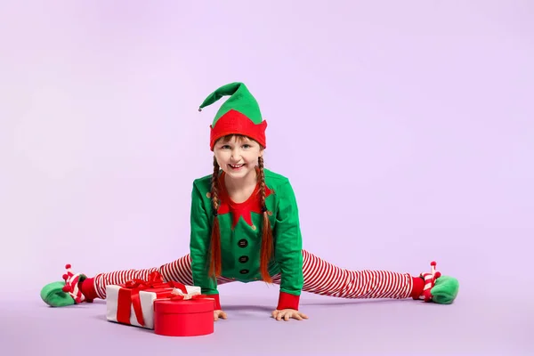 Bambina in costume da elfo e con regali sullo sfondo a colori — Foto Stock