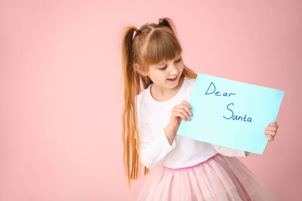 Cute little girl with letter to Santa Claus on color background — Stock Photo, Image