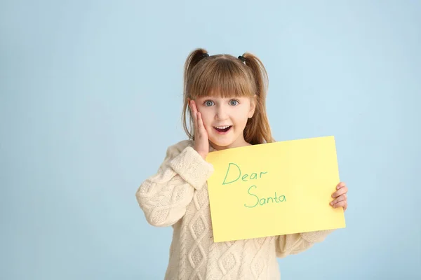 Excited little girl with letter to Santa Claus on light background — ストック写真
