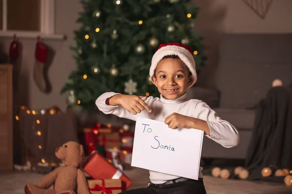 Carino ragazzo afroamericano con lettera a Babbo Natale la vigilia di Natale a casa — Foto Stock