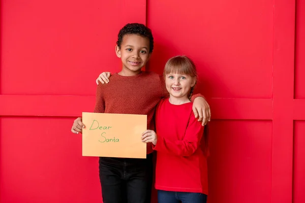 Aranyos kis gyerekek levél Mikulás a színes háttér — Stock Fotó