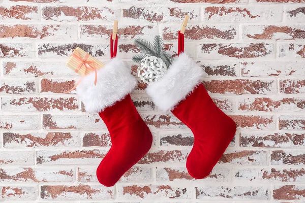 Karácsonyi zokni ajándékokkal lógó téglafal — Stock Fotó