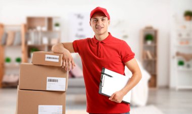 Kapalı alanda kutuları ve panosu olan teslimatçı.