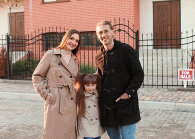 Yeni evlerinin yanında genç bir aile.