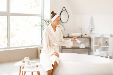 Güzel genç bayan rahatlatıcı bir banyo hazırlıyor.