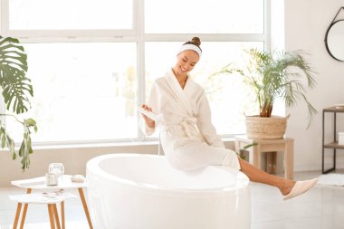 Güzel genç bayan rahatlatıcı bir banyo hazırlıyor.
