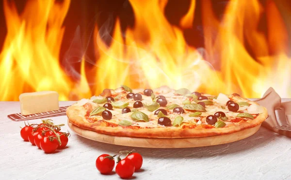 Gorąca pizza z płomieniem na stole — Zdjęcie stockowe