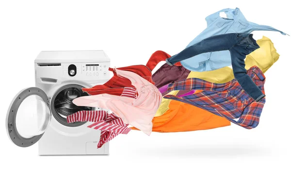 Modern washing machine and flying laundry on white background — ストック写真