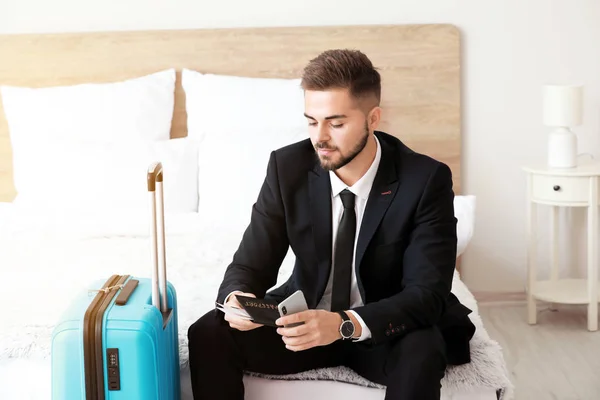 Young man with luggage for business trip at home