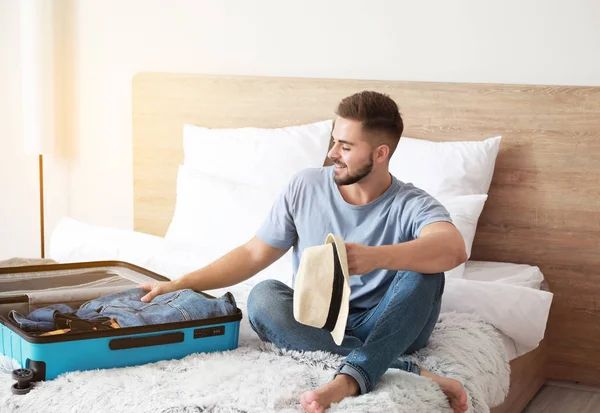 Young man packing luggage at home — Stock Photo, Image