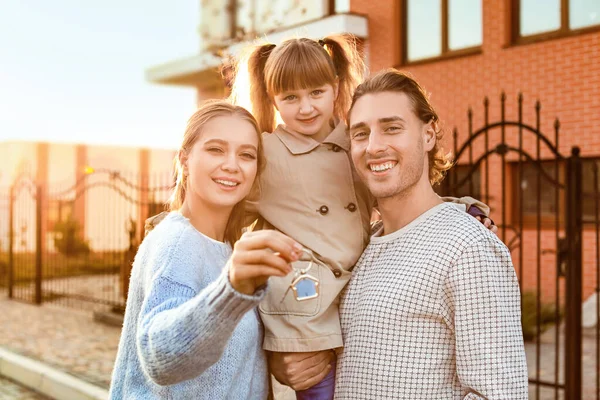 Jeune famille avec clé près de leur nouvelle maison — Photo