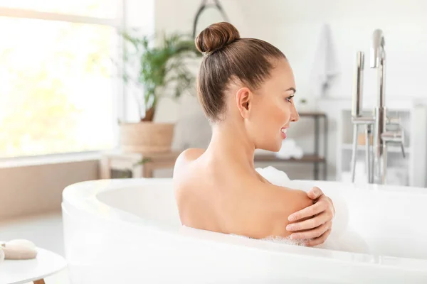 Schöne junge Frau entspannt sich in Badewanne — Stockfoto