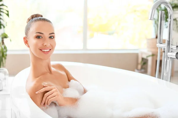 Beautiful young woman relaxing in bathtub — Stock Photo, Image