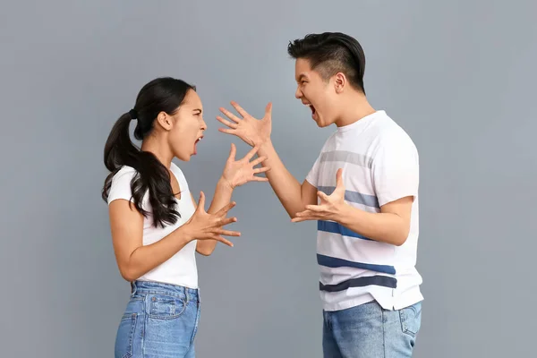 Quarrelling asiatiska par på grå bakgrund — Stockfoto