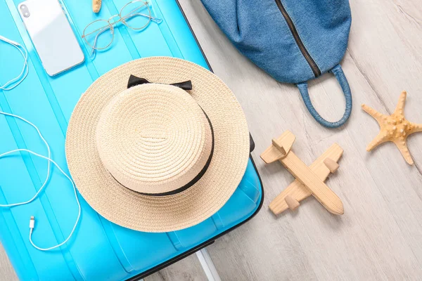 Suitcase with hat, mobile phone and bag on floor — Stock Photo, Image