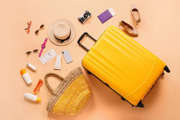 Suitcase with travel accessories on color background — Stock Photo, Image