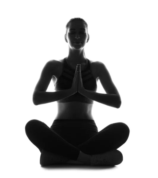 Silhouette of sporty young woman practicing yoga on white background — Stock Photo, Image